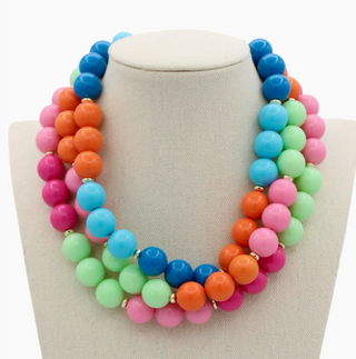 Colorful beaded necklace on a white stand