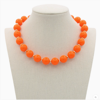 Orange beaded necklace on a white mannequin bust