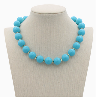 Turquoise beaded necklace on a gray bust