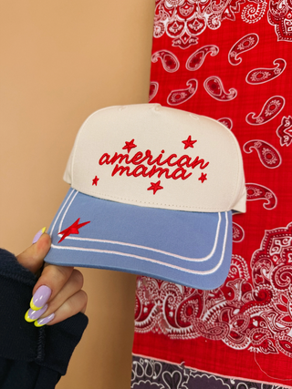 Cap with 'American Mama' text held by a hand against a red bandana background