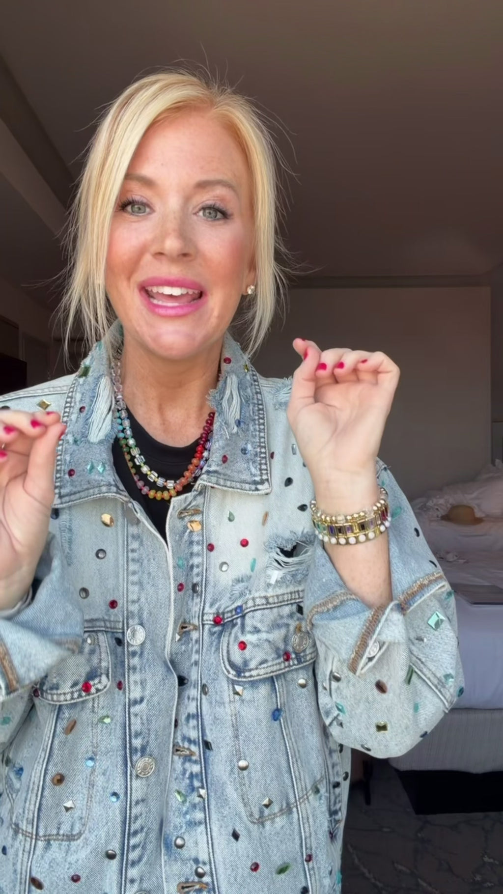Southern Quirks Try on Video for an oversized denim jacket that is embellished with colorful gemstones.  Model pairs this jacket with a black set and colorful jewelry.  Compliment Magnet statement piece.