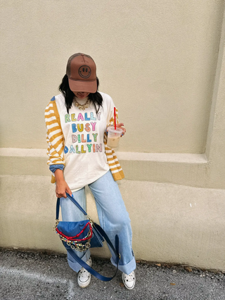 girl in stylish outfit with shirt that says really busy dilly dallying on it