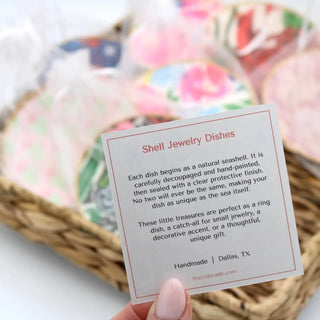 Shell jewelry dishes with a descriptive card held by a hand